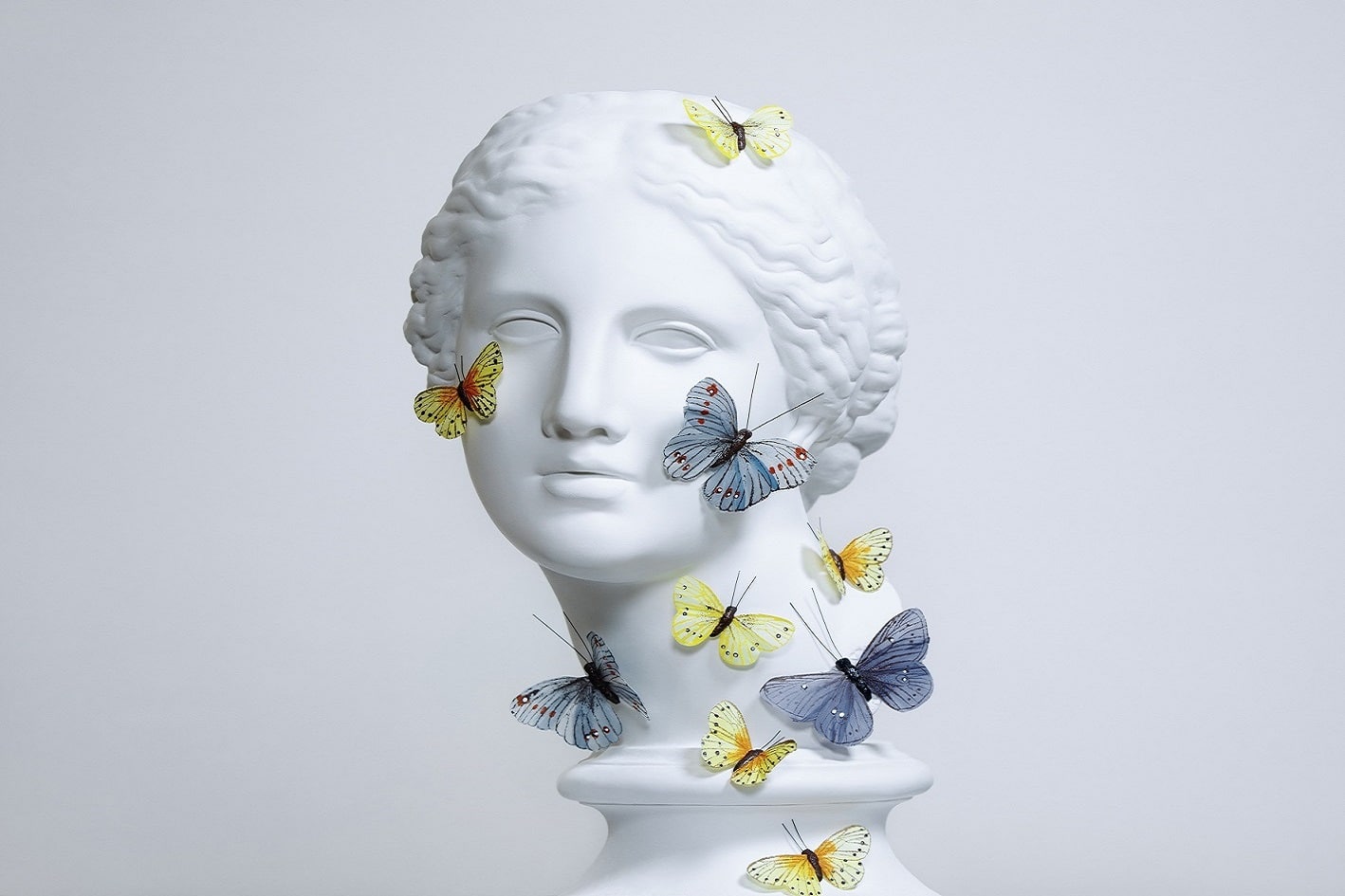 Bild einer weiblichen Statue mit gelben und blauen Schmetterlingen